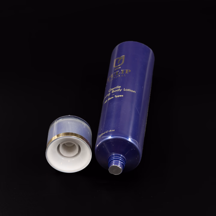 Navy plastic lotion tube with clear cap and gold detail, cap off